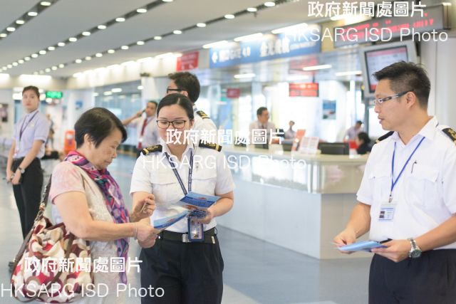 Marine Inspectors of the Marine Department distribute promotional leaflets to passengers at the waiting lounge of the Hong Kong-Macau Ferry Terminal in Sheung Wan today (September 7) to encourage them to fasten their seat belts at the appropriate time to ensure a safer sea journey.