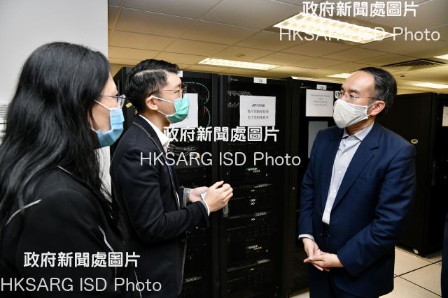 The Secretary for Financial Services and the Treasury, Mr Christopher Hui, visited the Rating and Valuation Department today (May 28). Photo shows Mr Hui (first right) being briefed on the electronic system by a colleague from the Computer Division.